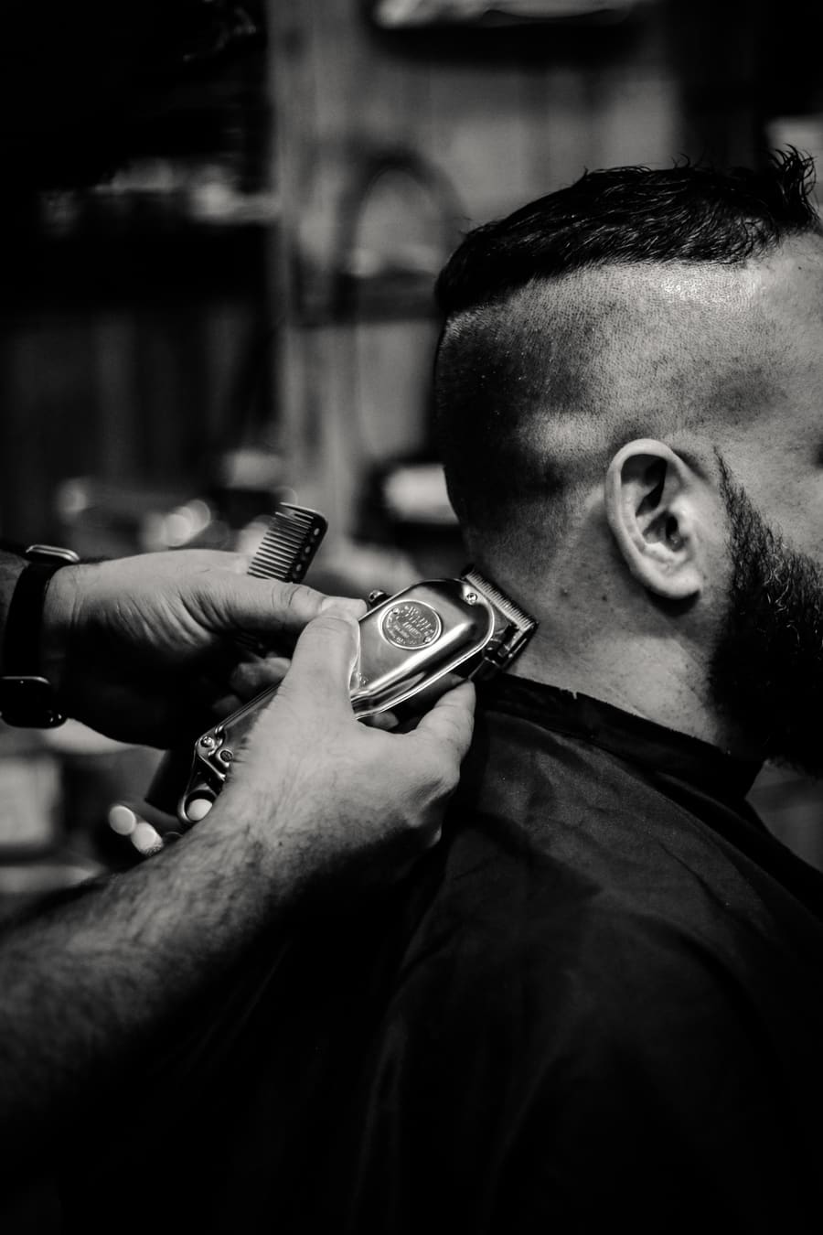Barbeiro aparando o cabelo de um cliente